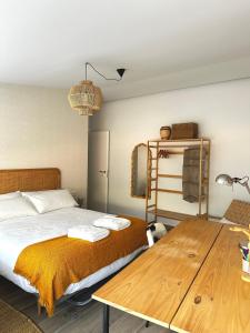 a bedroom with a bed and a wooden table at Casa Tilin in Valtierra +19 photos