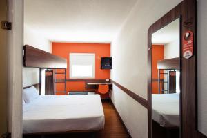 Una pequeña habitación con dos camas y un espejo. en Hotel Hi! Zapopan, en Guadalajara 13 fotos más