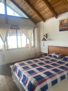 a bedroom with a bed in a room with windows at kontiki in Máncora