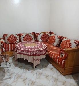 een bank met een tafel in de woonkamer bij Zina résidence in Aourir