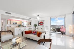 Una sala de estar con un sofá blanco y una cocina. en Resort-Style Living with Direct Ocean Views - 3BR Beauty, en Hallandale Beach 47 fotos más
