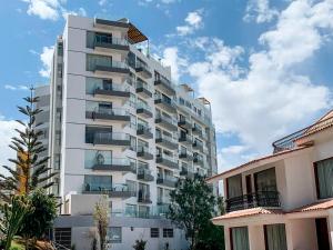 a tall white apartment building with balconies on it at LUXURY CAYMA 2 - Impresionante vista a la campiña sin salir de la ciudad in Arequipa