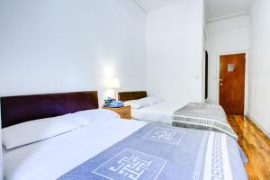 ロンドンにあるHyde Park 36 Hotelの白いシーツが敷かれたベッドが2つあるホテルの部屋