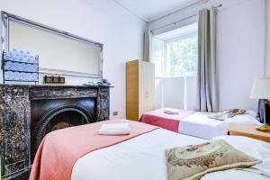 ロンドンにあるHyde Park 36 Hotelの暖炉付きの部屋のベッド2台