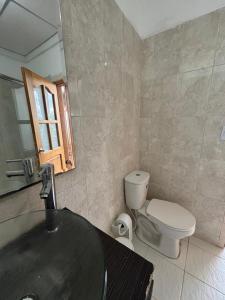 a bathroom with a sink and a toilet and a mirror at Hostal Santa Teresita in La Merced +26 photos