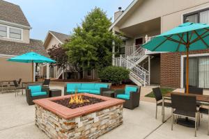a patio with a fire pit and chairs and umbrellas at MainStay Suites St Louis - Galleria in Richmond Heights