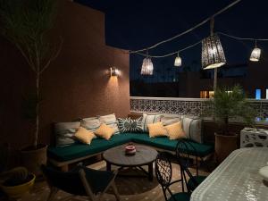 un divano su un patio con tavolo e sedie di "LE 21", EXCLUSIVE LUXURY DUPLEX 400m FROM JEMAA EL FNA PLACE -HAMMAM-JACUZZI-KOUTOUBIA VIEW-ROOF TERRACE -SPEED WIFI a Marrakech