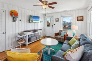 a living room with a couch and a table at 5050 - Sea Haven in Kill Devil Hills