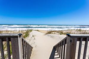 a wooden staircase leading to a beach with the ocean at 5050 - Sea Haven in Kill Devil Hills