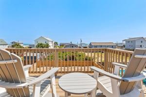 - deux chaises et une table sur une terrasse donnant sur l'océan dans l'établissement 5000 - Finn's Coastal Cottage, à Avalon Bench