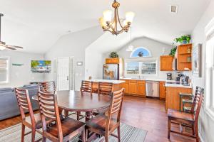 une cuisine et une salle à manger avec une table et des chaises en bois dans l'établissement 5000 - Finn's Coastal Cottage, à Avalon Bench 58 autres photos