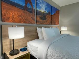 Una habitación de hotel con una cama y cuadros en la pared. en Days Inn by Wyndham Sulphur Springs, en Sulphur Springs