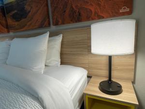 Un dormitorio con una cama y una lámpara sobre una mesa. en Days Inn by Wyndham Sulphur Springs, en Sulphur Springs
