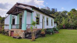 a small house with a green and white at Camping Tiradentes in Tiradentes