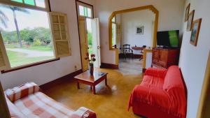 a living room with two red couches and a television at Camping Tiradentes in Tiradentes