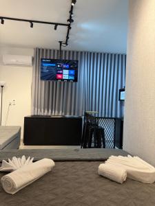 two white towels on a floor in a room with a tv at Studio lnhô Tim in Brumadinho