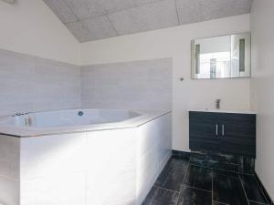 Un baño blanco con bañera y lavabo. en Luxury Retreat in Blavand - By Traum Ferienwohnungen, en Blåvand