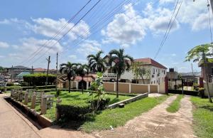 a yard with palm trees and a building at D Barfi Executive Lodge, excellent location in Kumasi