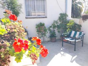 a patio with flowers and a chair in front of a house at Hotel El Descanso in Junín
