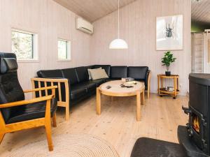a living room with a black couch and a table at Luxury Spa Retreat in Blavand - By Traum Ferienwohnungen in Blåvand