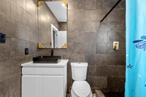 ein Badezimmer mit Waschbecken, Toilette und Spiegel in der Unterkunft Heights Charm Cozy & Group Stay - Sleeps10 in Houston