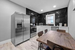 eine Küche mit Holztisch und Edelstahlkühlschrank in der Unterkunft Heights Charm Cozy & Group Stay - Sleeps10 in Houston