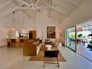 a living room with a couch and a table at Villa Les Oliviers - Élégance & Sérénité in Les Terres Basses