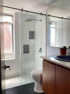 a bathroom with a toilet and a glass shower at Bogotá Urban Suites in Bogotá +24 photos