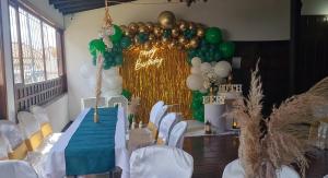 a room with a table with green and white balloons at Hotel MAXIRUMA - Villa TAMAUKA in Iza