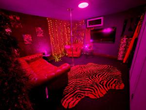 a living room with a zebra rug and a room with purple lights at Love room avec spa privatif et salle de jeux adultes in Beauvais