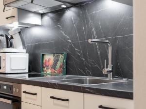a kitchen with a sink and a black wall at Landhaus Marchfeld Top 5 in Wildschönau +28 photos