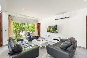 a living room with two couches and a tv at Villa Deluxe SlowLiving Tulum CountryClub Golf PGA in Akumal