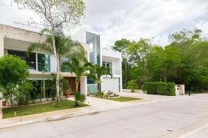 an empty street in front of a white building at Villa Deluxe SlowLiving Tulum CountryClub Golf PGA in Akumal