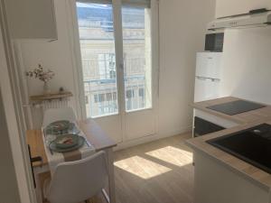 a small kitchen with a table and a window at Cocooning BNB in Châteauroux