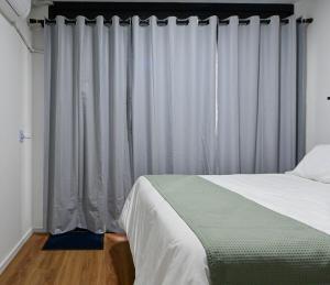 1 dormitorio con cama y cortinas blancas en 18NV Studio Liberdade SP 300 m Estação Japão Liberdade, en São Paulo 29 fotos más