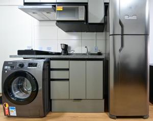 una cocina con nevera y lavadora en 18NV Studio Liberdade SP 300 m Estação Japão Liberdade, en São Paulo