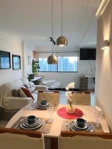 a kitchen and living room with a table and chairs at Flat Parque da Jaqueira in Recife