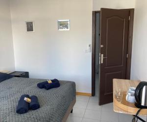 a bedroom with a bed with blue slippers on it at TIPANIER - City center room Papeete in Papeete