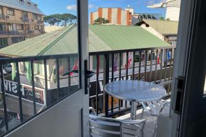 a table and chair on the balcony of a building at TIPANIER - City center room Papeete in Papeete +5 photos