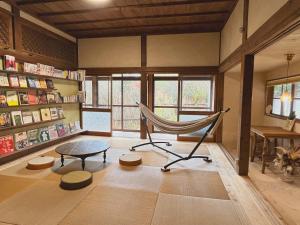 Yamanoにあるその火暮らし Sonohigurashi - Life with Fire Guesthouseのハンモック、テーブル、デスクが備わる客室です。