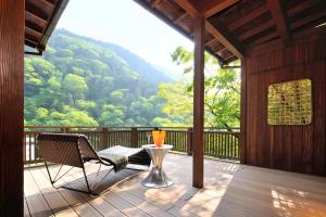 weranda z 2 krzesłami i stołem z wazonem w obiekcie 山の茶屋 w mieście Hakone