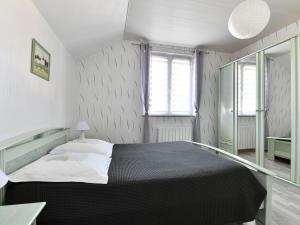 a bedroom with a black and white bed and a window at Gîte convivial avec terrasse abritée, 3 chambres, cuisine équipée, espace détente, proche autoroutes et pistes cyclables. - FR-1-744-6 in Baldersheim