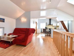 a living room with a red couch and a table at Gîte convivial avec terrasse abritée, 3 chambres, cuisine équipée, espace détente, proche autoroutes et pistes cyclables. - FR-1-744-6 in Baldersheim