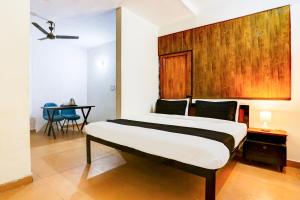 新德里Super Hotel O KC的卧室里有一张带木质床头板的大床