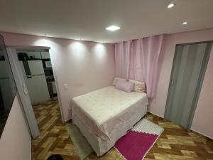 a small bedroom with a bed and a mirror at Casa rosa in Sao Paulo