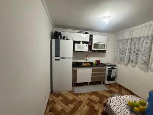 a kitchen with a white refrigerator and a counter at Casa rosa in Sao Paulo