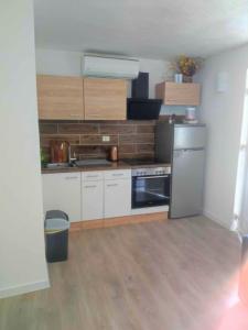 a kitchen with white cabinets and a stove top oven at Apartments with parking space Trpanj, Peljesac - 15976 in Trpanj