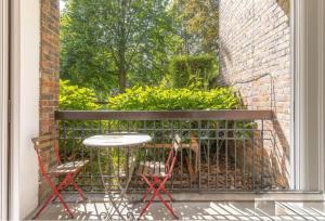 a patio with a table and two chairs and a window at Entire Bright & Spacious Apartment in Greater London, United Kingdom in Maida Vale