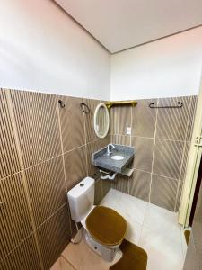 Santa InêsにあるApto aconcheganteのバスルーム(洗面台、鏡付きのトイレ付)