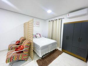 Santa InêsにあるApto aconcheganteのベッドと椅子のある小さな寝室